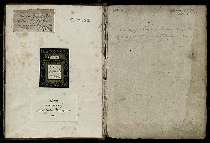 Endpapers of an old book. On it are a few lines of notes in pencil, a bookplate and a section of old handwriting that has been cut from elsewhere.