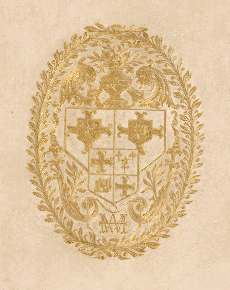 A close-up detail of an elaborate goat of arms stamped in gold on discoloured vellum. The coat of arms contains the monogram 'W.M'.